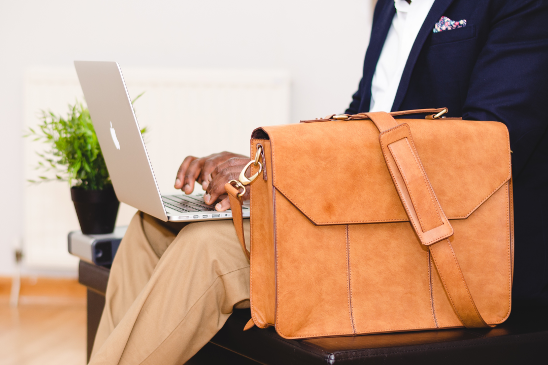 male traveller in suit typing on laptop