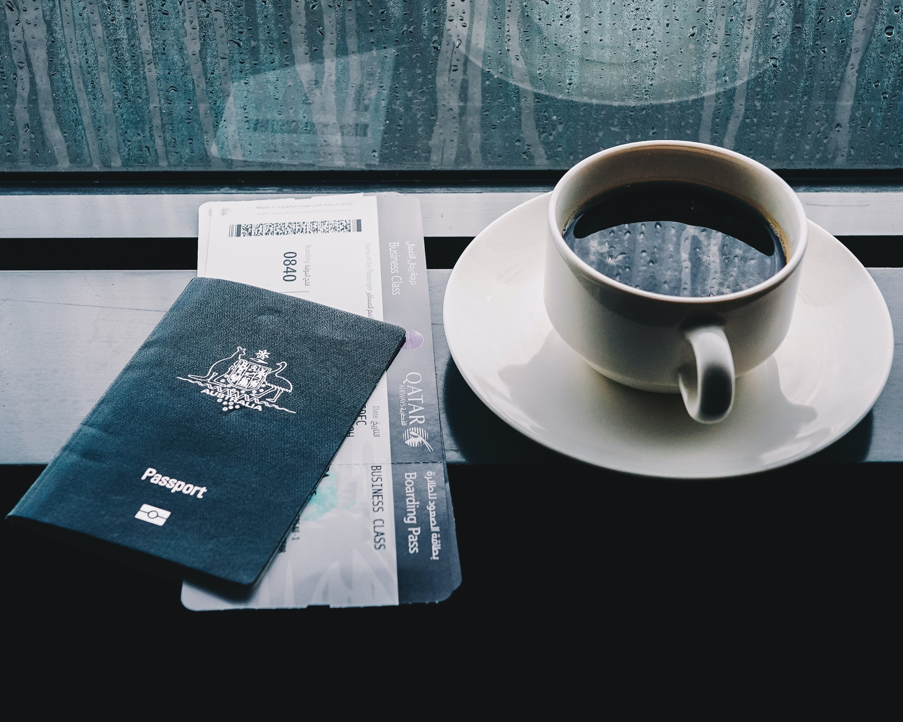 australian passport next to cup of coffee
