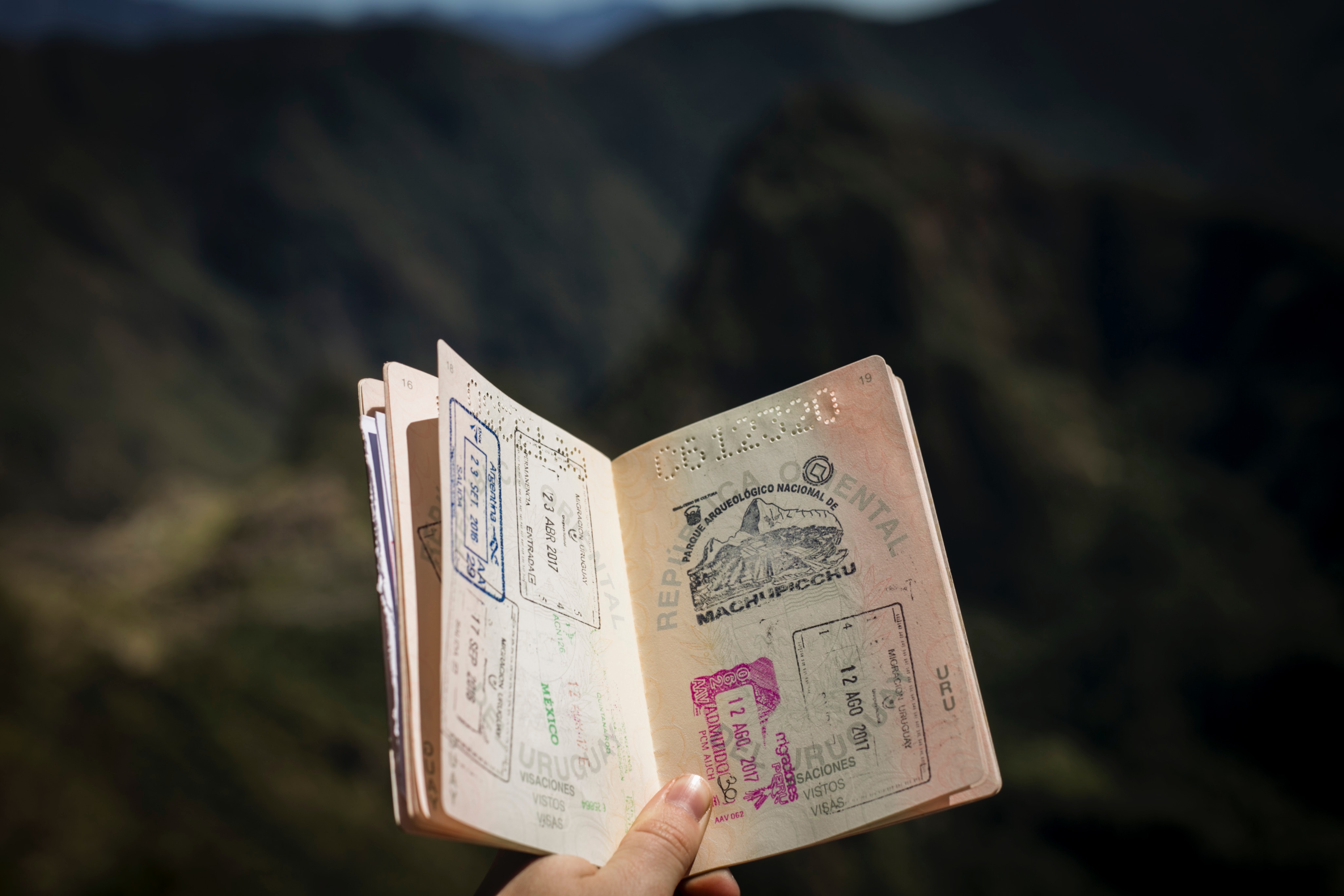 person holding open passport with stamped pages