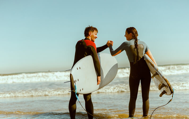 friends surfing together in ocean